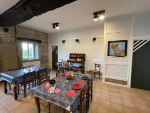a dining room with tables and chairs and a room with a tableablish at La Ferme Delaunay in Saint-Côme-du-Mont
