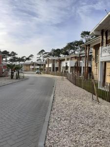 an empty street with houses and a fence at Dune Blanche 300 m de l'Océan, appartement neuf 6 personnes in Seignosse