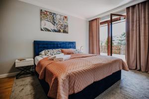 sypialnia z łóżkiem i dużym oknem w obiekcie VisitZakopane - Szarotka Apartment w Zakopanem