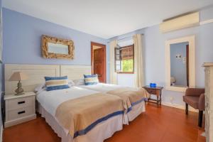 a bedroom with a large bed with blue walls at La Tartana Hotel Boutique in La Herradura