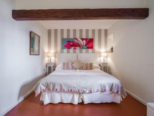 a bedroom with a white bed and two lamps at La Tartana Hotel Boutique in La Herradura
