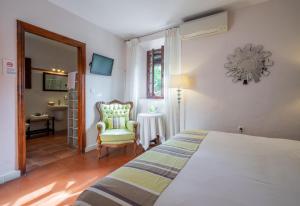 a bedroom with a bed and a chair and a mirror at La Tartana Hotel Boutique in La Herradura