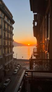 einen Blick auf den Sonnenuntergang vom Balkon eines Gebäudes in der Unterkunft B&B Orsini 46 in Neapel