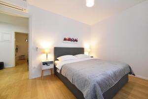ein Schlafzimmer mit einem großen Bett und einer weißen Wand in der Unterkunft Ophelia Apartment with parking in Zagreb