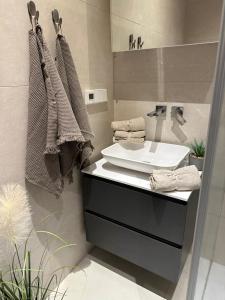 baño con lavabo y encimera con toallas en Riga Center - Quiet Studio - 5 min to Old Town & NFLX, en Riga
