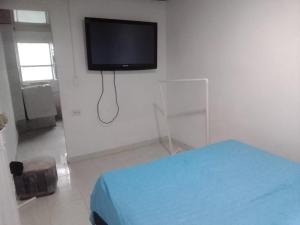 a room with a bed and a flat screen tv on the wall at Apartamento independiente para pareja in Villavicencio