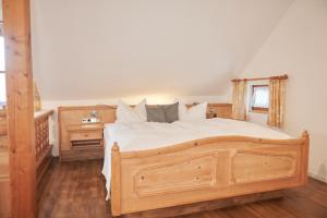 Un dormitorio con una gran cama de madera y una ventana en Haus Ranker, en Reit im Winkl