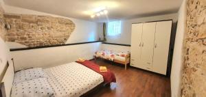 a bedroom with a bed and a dresser in it at Rustic Istrian Stone House in Ližnjan