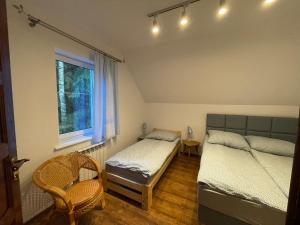 a bedroom with two twin beds and a window at Leśnisko in Jerutki