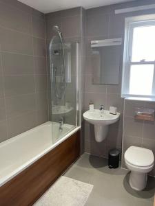 ein Bad mit einer Dusche, einem WC und einem Waschbecken in der Unterkunft Lovely 2-bed flat with well equipped kitchen in Ealing