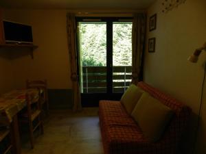 uma sala de estar com um sofá e uma janela em Appartement Le Pleynet, 2 pièces, 5 personnes - FR-1-557A-45 em La Ferrière