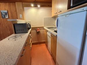 a kitchen with a white refrigerator and a stove at Appartement pour 6 personnes avec balcon, wifi gratuit et casier à skis - FR-1-508-267 in Lanslevillard