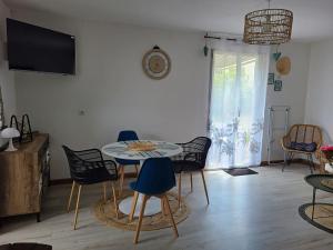 uma sala de estar com mesa e cadeiras em Gîte La Vôge-les-Bains, 3 pièces, 4 personnes - FR-1-589-418 em Harsault