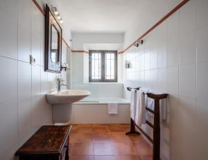 ein weißes Badezimmer mit einem Waschbecken und einer Badewanne in der Unterkunft La Tartana Hotel Boutique in La Herradura