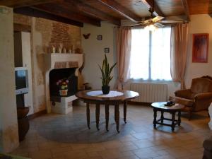 sala de estar con mesa y chimenea en Gîte Val-de-Bonnieure, 4 pièces, 6 personnes - FR-1-653-26 