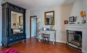 a room with a fireplace and a desk and a mirror at La Tartana Hotel Boutique in La Herradura
