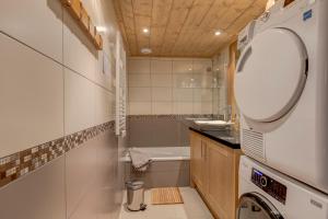 a bathroom with a tub and a sink and a mirror at Chalet des Oursons in Cohennoz +10 photos