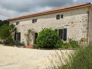 a white brick building with a bike in front of it at Maison spacieuse en pleine nature avec piscine, équipements de loisirs et randonnées à proximité - FR-1-653-105 in Nonac