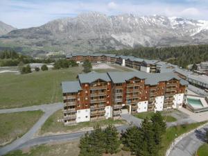 una vista aerea di un edificio con montagne sullo sfondo di Appartement Le Dévoluy, 2 pièces, 4 personnes - FR-1-525-250 a Le Dévoluy