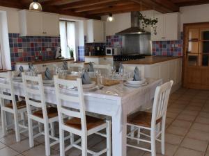 a kitchen with a large white table and chairs at Maison spacieuse en pleine nature avec piscine, équipements de loisirs et randonnées à proximité - FR-1-653-105 in Nonac