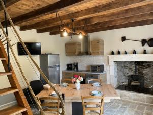 eine Küche mit einem Holztisch mit Stühlen und einem Kamin in der Unterkunft Gîte Val-de-Bonnieure, 3 pièces, 4 personnes - FR-1-653-214 