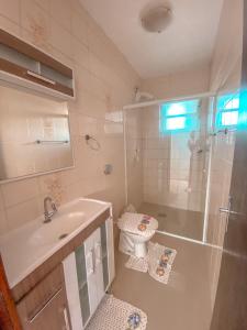 een badkamer met een wastafel, een toilet en een douche bij Casa de Praia Pinheira in Palhoça