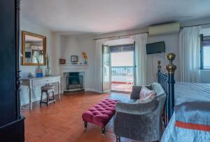 a bedroom with a bed and a living room with a fireplace at La Tartana Hotel Boutique in La Herradura