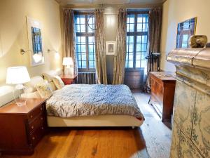 1 dormitorio con 1 cama, escritorio y ventanas en Maison D'Ammann, en Fribourg