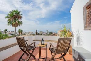 a patio with two chairs and a table on a balcony at La Tartana Hotel Boutique in La Herradura