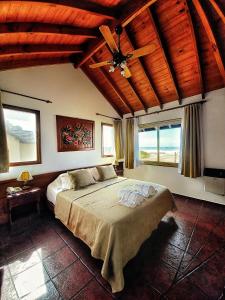 Un dormitorio con una cama y un ventilador de techo. en Orillas del Mar, en Villa Gesell