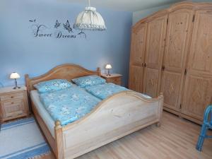 sypialnia z łóżkiem z niebieską pościelą i drewnianymi szafkami w obiekcie Ferienwohnung Gaul w mieście Riedenburg