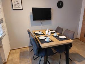 a dining room table with chairs and a tv at Ferienwohnung Gaul in Riedenburg