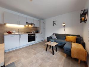a living room with a couch and a kitchen at Ferienwohnung Gaul in Riedenburg