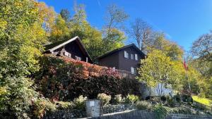 a house with a hedge in front of it at Romantic private superior Swiss Chalet with Hottub in Lungern