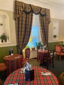 een restaurant met tafels en stoelen en een raam bij Cornerways Guest House in Carlisle