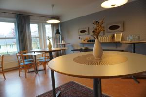 ニーショーピンにあるNygården Stjärnholmのテーブルと椅子、テーブルの上に花瓶が備わる部屋