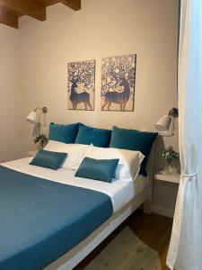 un letto con lenzuola e quadri blu e bianchi sul muro di Loft Penelope a Tivoli