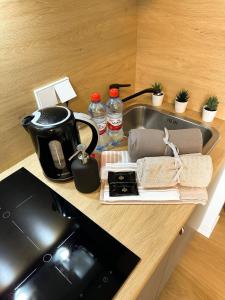 a kitchen counter with a sink and a stove at Riga Center - Quiet Studio - 5 min to Old Town & NFLX in Rīga