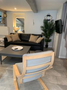 een woonkamer met een bank en een tafel bij La Maison Bleue, proche de tout in Le Tréport