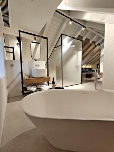 a bathroom with a white tub and a mirror at Zuviteo Residence in Korčula