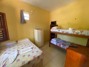 a room with two bunk beds and a refrigerator at Pousada do Ary in Jericoacoara