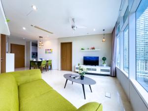 a living room with a yellow couch and a table at Vortex suites klcc by Surat in Kuala Lumpur