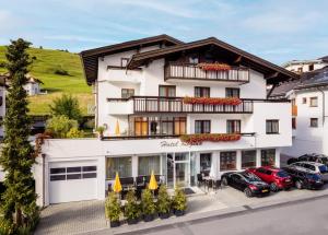 een hotel met auto's voor het hotel bij Hotel Regina in Serfaus