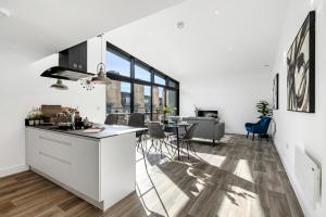a kitchen and living room with white cabinets and a table at Tailored Stays - Central Cambridge, Lacon House in Cambridge