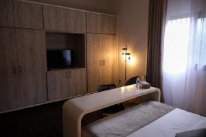 アビジャンにあるVilla Ayabaのベッド、デスク、テレビが備わるホテルルームです。
