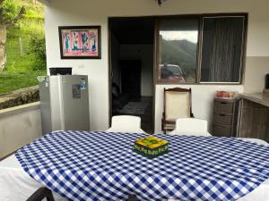Monteverde Holiday Apartments في بوغا: مطبخ مع طاولة مع قطعة قماش من اللون الأزرق والأبيض