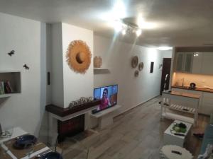 sala de estar con TV de pantalla plana en la pared en Kalle Blanca - Cabo Roig, en Cabo Roig