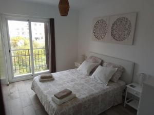 een slaapkamer met een bed met twee handdoeken erop bij Kalle Blanca - Cabo Roig in Cabo Roig