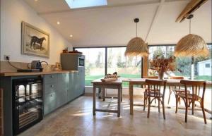 a kitchen with a table and chairs and a dining room at Le loft Normand avec piscine chauffée in Saint-Antonin-de-Sommaire