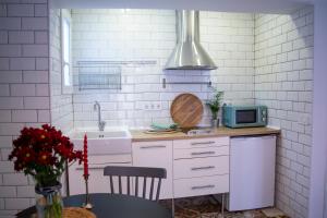 a white kitchen with a sink and a microwave at Nido MAD in Madrid